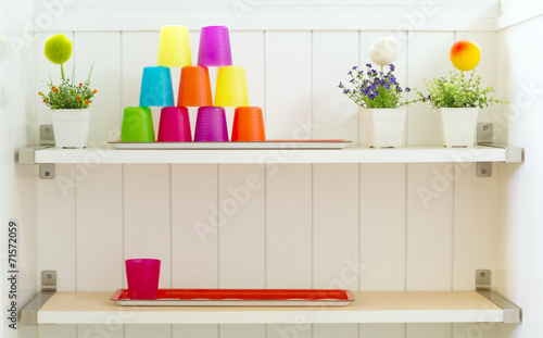 Plastic color cup on white shelf