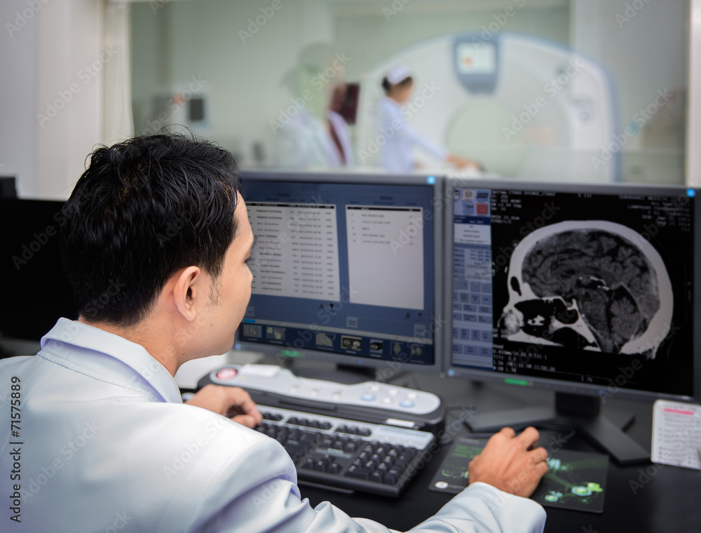 Medical team operating computers in CT scan lab Medical team operating computers in CT scan lab