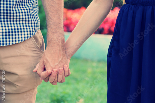 Young couple holding hands, outdoors