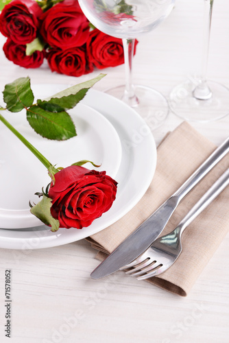 Table setting with red rose on plate