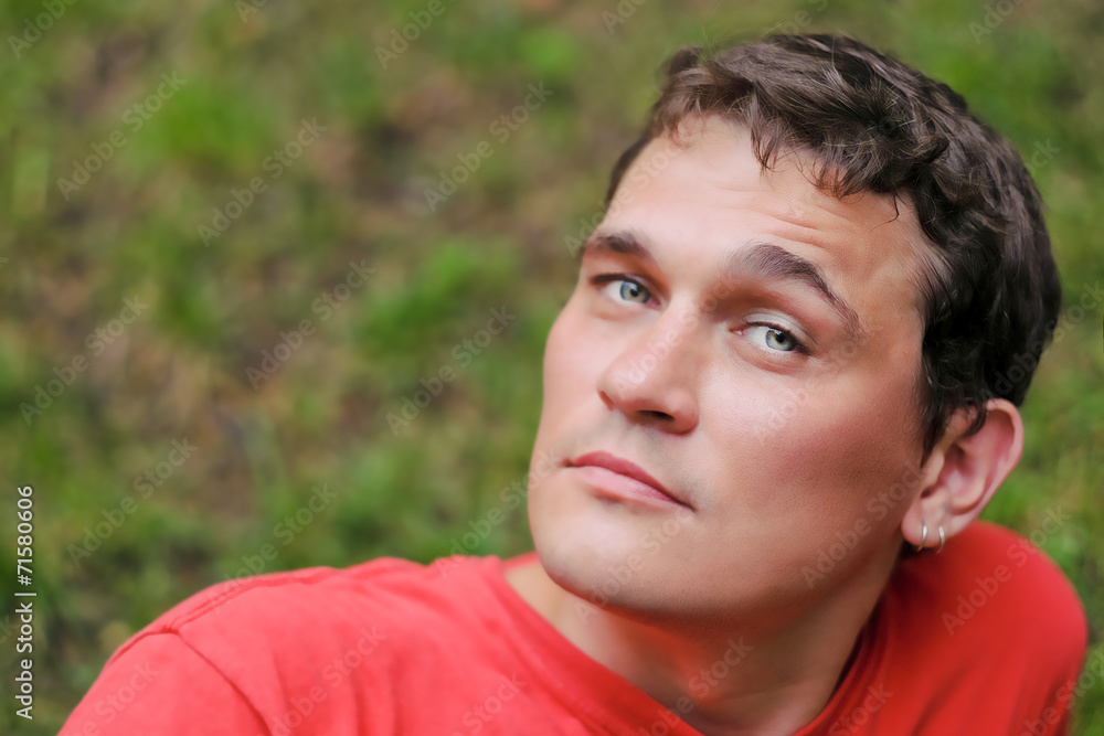 pensive young man relaxing in a park pensive young man relaxing in a park