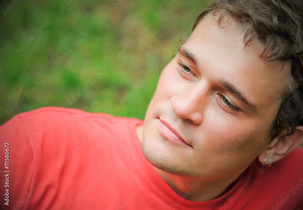 pensive young man relaxing in a park pensive young man relaxing in a park