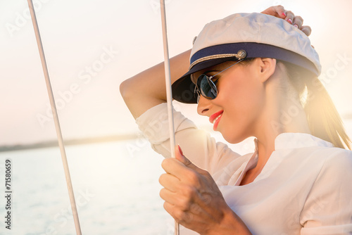 Adorable model wearing sea admirals hat and sexy top at sunset.