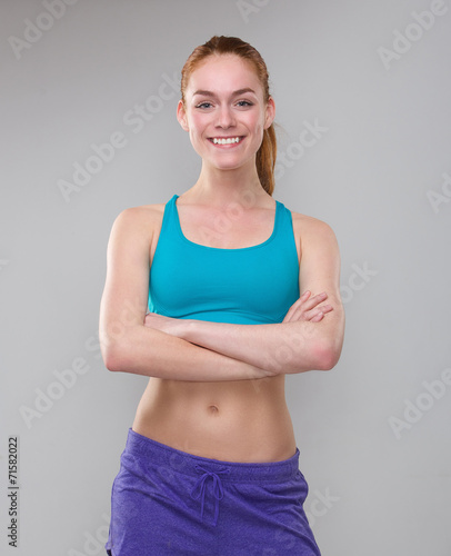 Beautiful sporty woman smiling with arms crossed