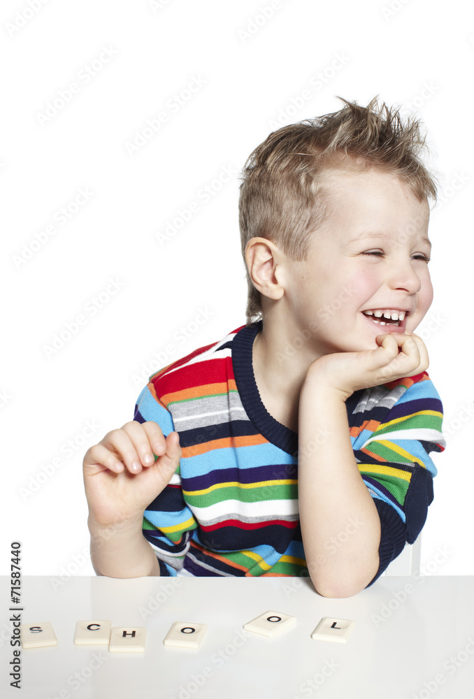 Schoolboy learning to spell with wooden letters, studio Schoolboy learning to spell with wooden letters, studio
