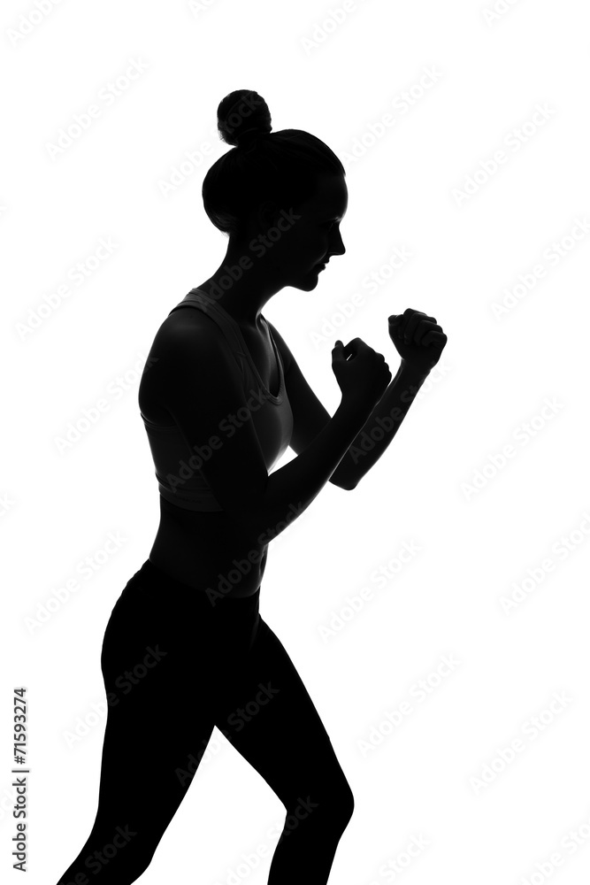 Silhouette of young woman with raised fists