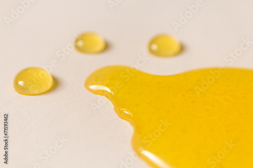 melting honey and drops on white background