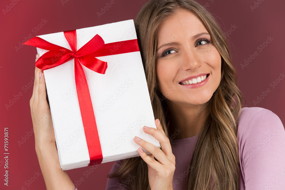 Gorgeous cute young woman holding present box. Gorgeous cute young woman holding present box.