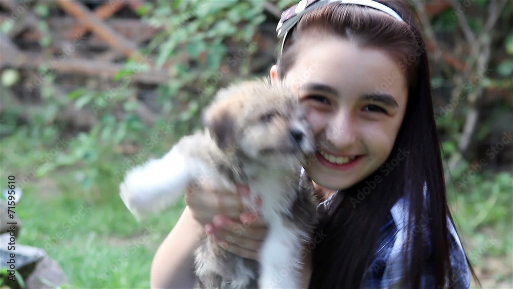 Girl cuddling a puppy outdoors in the garden Girl cuddling a puppy outdoors in the garden