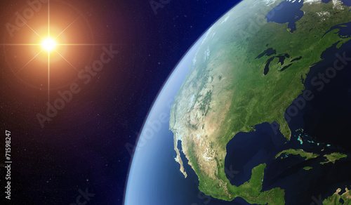 View of the North America from space lit by the sun.