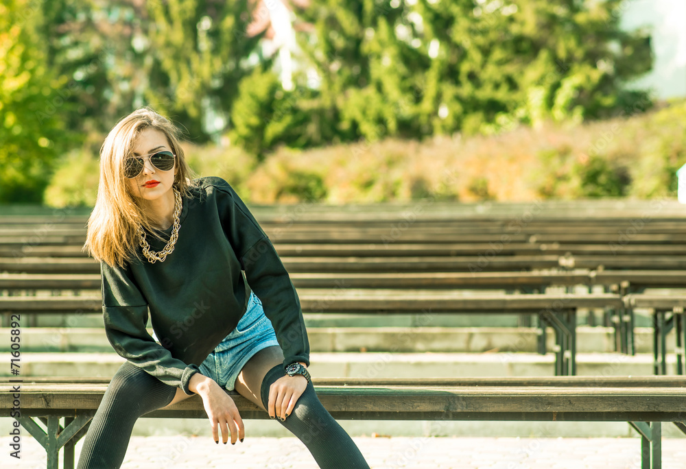 Young pretty girl sitting on bench in park Young pretty girl sitting on bench in park