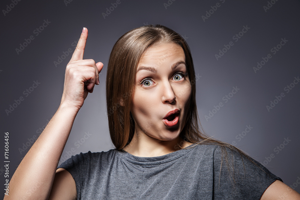 Woman having a good idea on dark grey Woman having a good idea on dark grey
