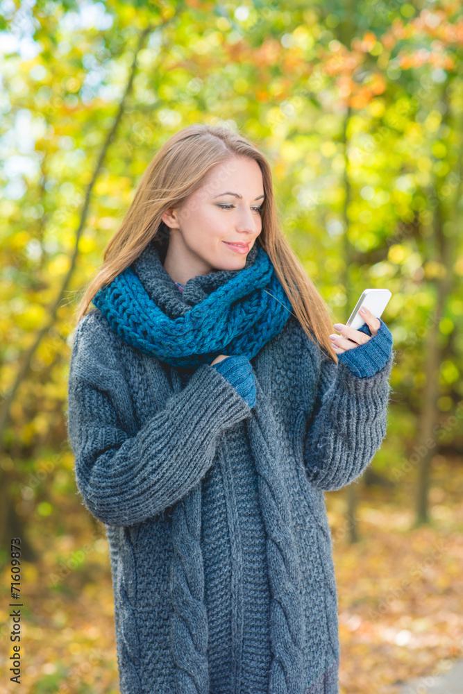 Young woman using a mobile outdoors in autumn Young woman using a mobile outdoors in autumn