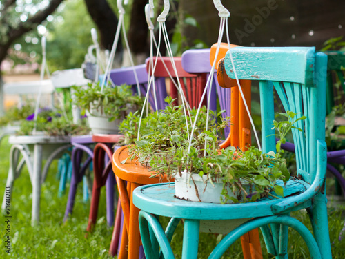 Colorful painted chairs on green grass