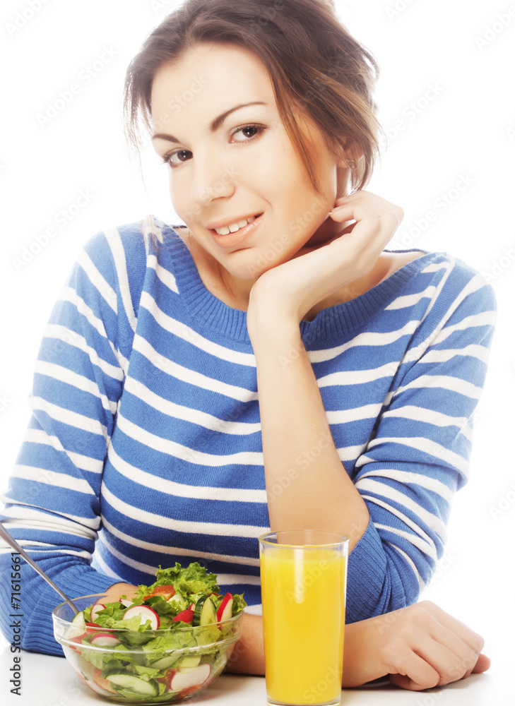 young woman has breakfast salad from fresh vegetables with oran young woman has breakfast salad from fresh vegetables with oran