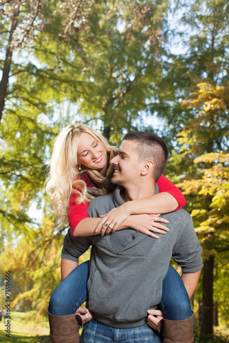 Young romantic couple with red umbrella in the park 