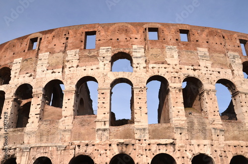 Majestatyczne coloseum w Rzymie na tle niebieskiego nieba, Włoch #71617629