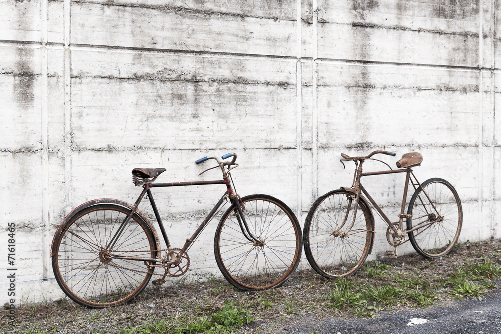 Antique or retro oxidized bicycle outside on a concrete wall