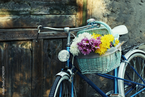 Old bicycle with flowers in metal basket #71619259