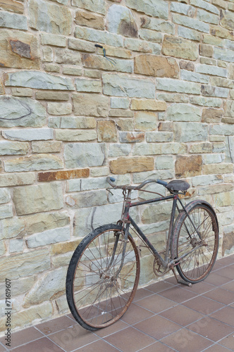 Antique or retro oxidized bicycle outside on a stone wall