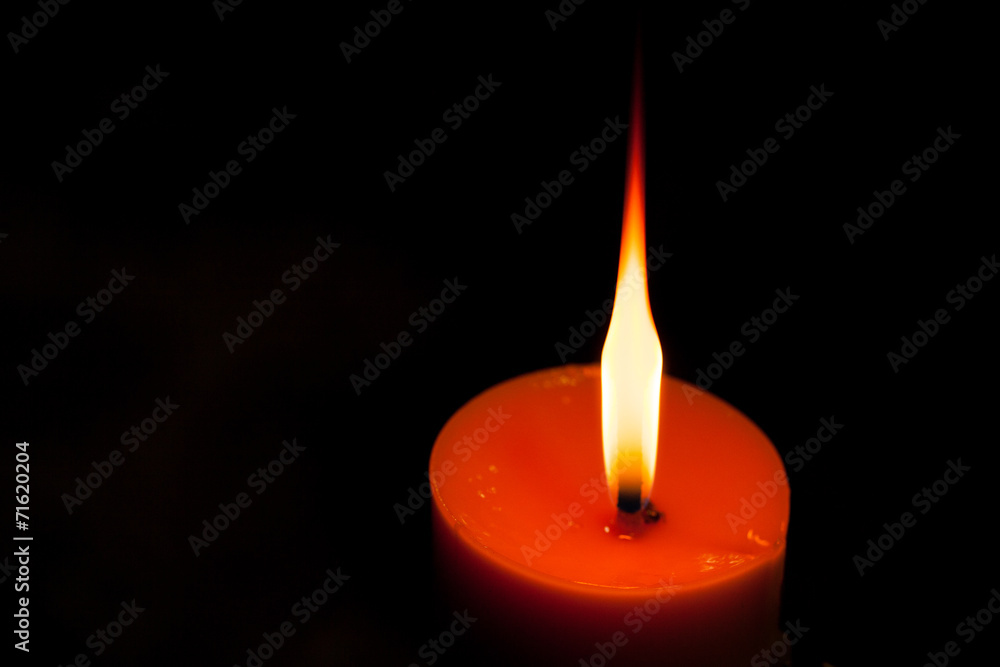 A burning candle in dark A burning candle in dark