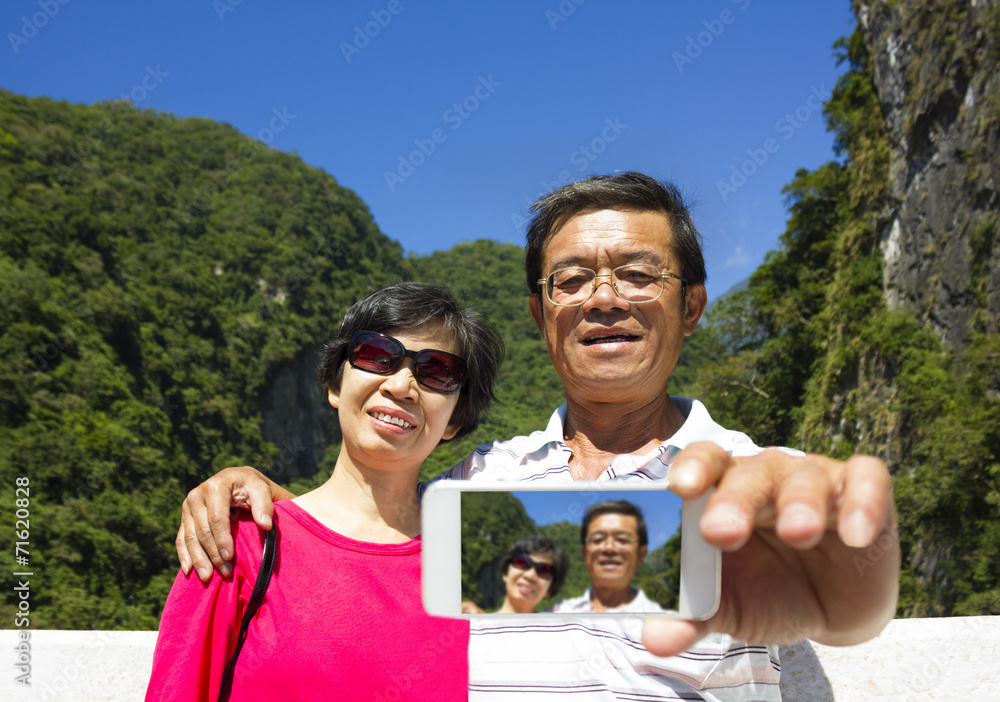 Senior couple taking picture of themselves outside