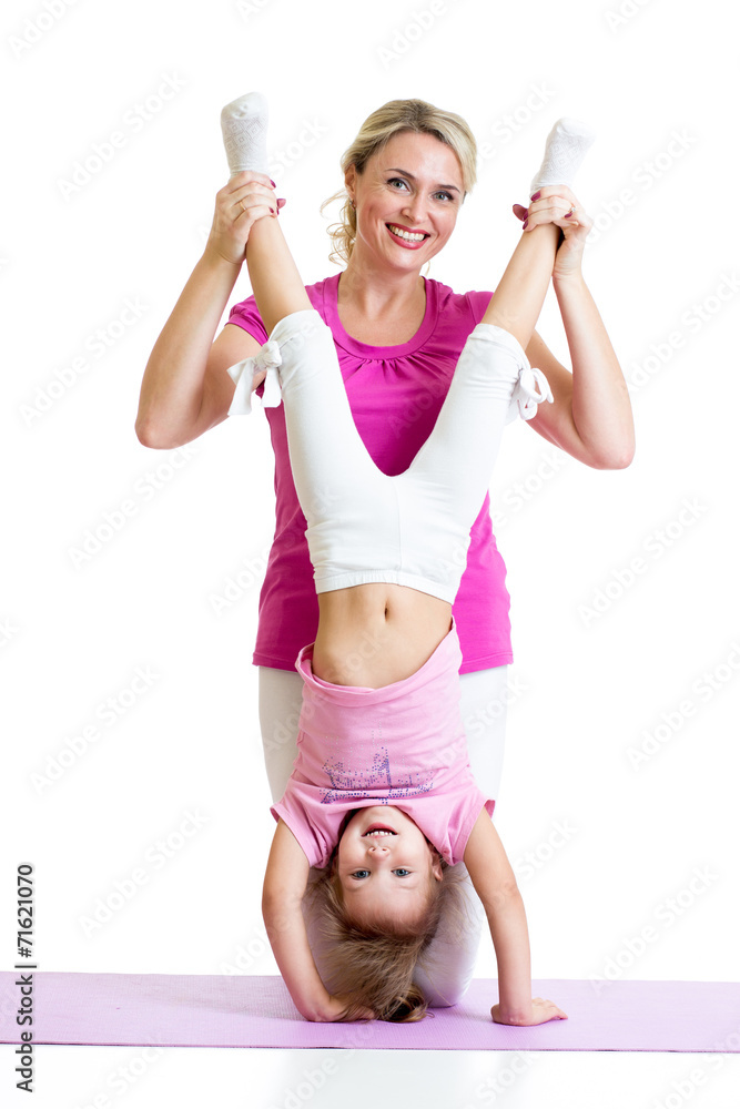 woman and kid daughter doing yoga exercise at mat woman and kid daughter doing yoga exercise at mat