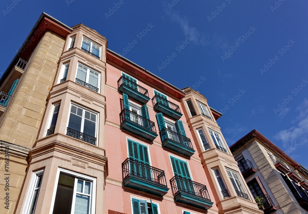 Façade d'immeuble au soleil, ciel bleu