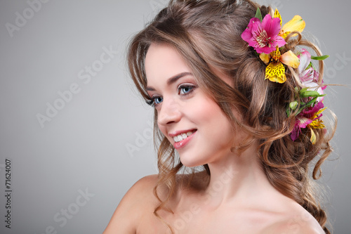 Beautiful girl with varicoloured flowers in hairs