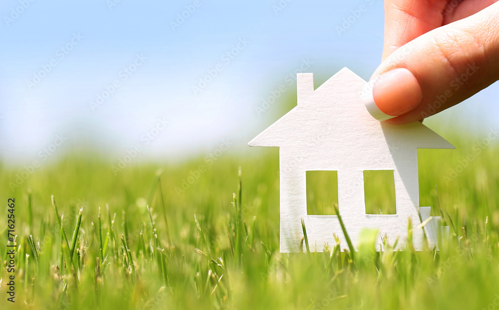 Paper house in green grass over blue sky. Mortgage concept - obrazy, fototapety, plakaty 