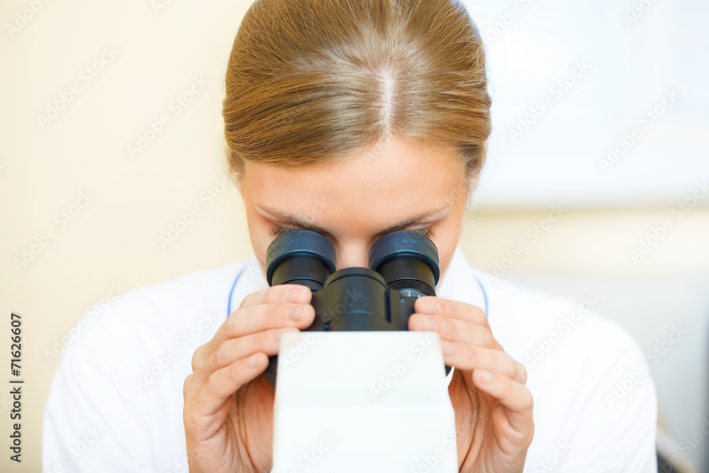 Woman working with a microscope.