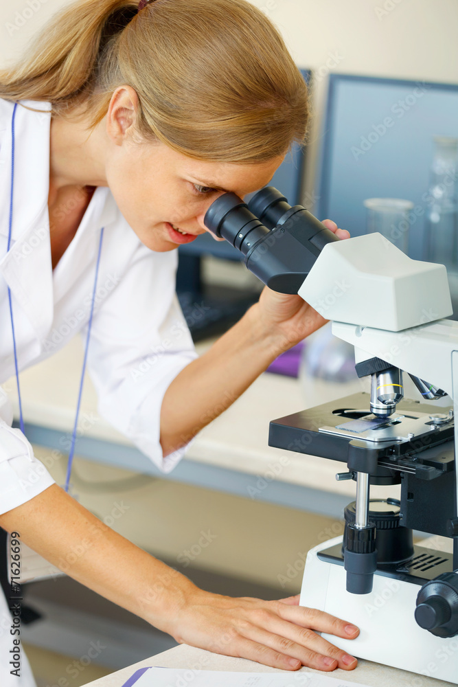 Woman working with a microscope. Woman working with a microscope.