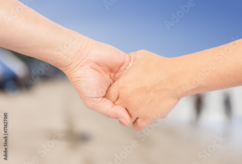 hand in hand with blur beach background © dextorth