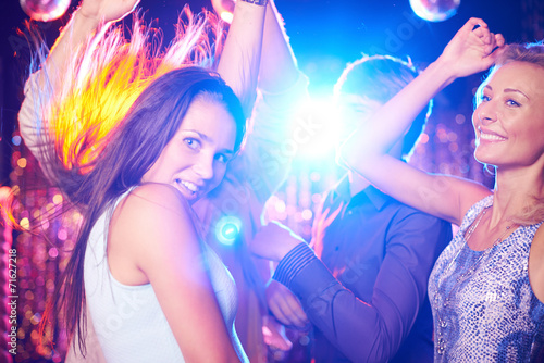 Energetic young people dancing in night club