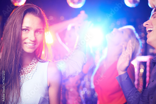 Atrakcyjna dziewczyna pozuje na parkiecie tanecznym w klubie nocnym