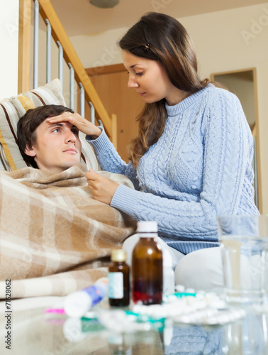 Woman caring for sick guy who high temperature photo