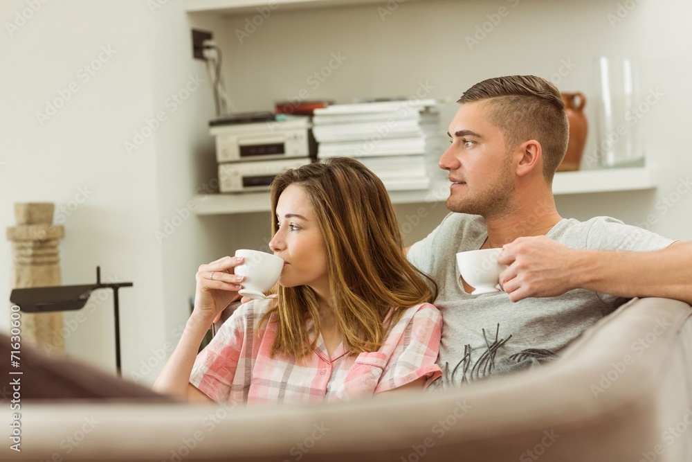 Cute couple relaxing on couch with coffee Cute couple relaxing on couch with coffee
