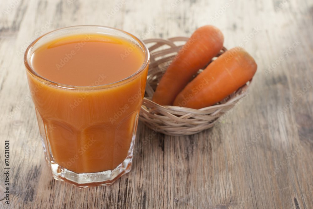 Carrot juice in a glass and carrots on the table. Carrot juice in a glass and carrots on the table.
