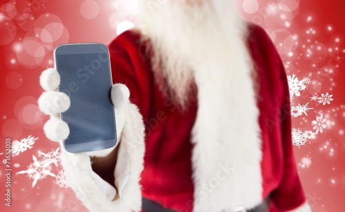 Composite image of santa claus showing smartphone