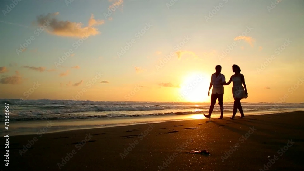 couple in love walking on the beach at sunset couple in love walking on the beach at sunset
