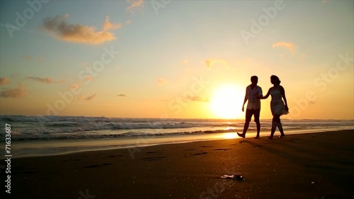 couple in love walking on the beach at sunset