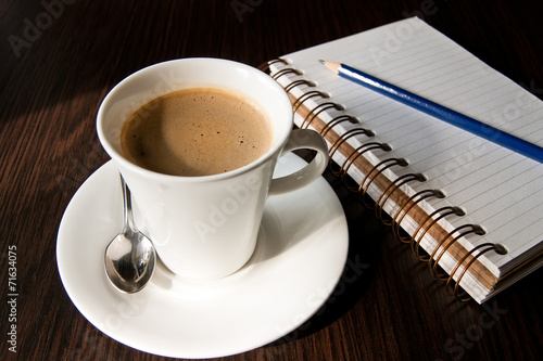 notebook pen and cup of coffee in wood table