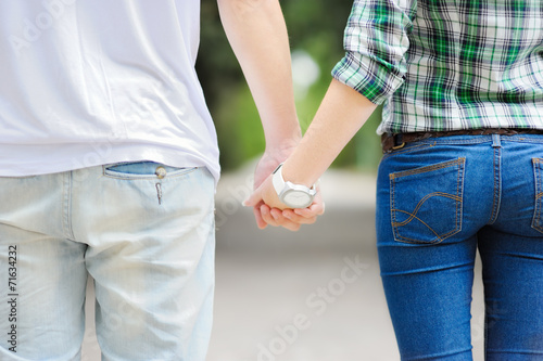 A young man with a young girl holding hands.