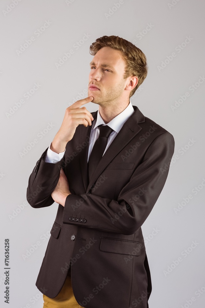 Young businessman thinking with hand on chin Young businessman thinking with hand on chin