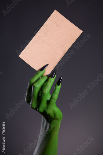Obraz na płótnie Green monster hand holding blank piece of cardboard w salonie