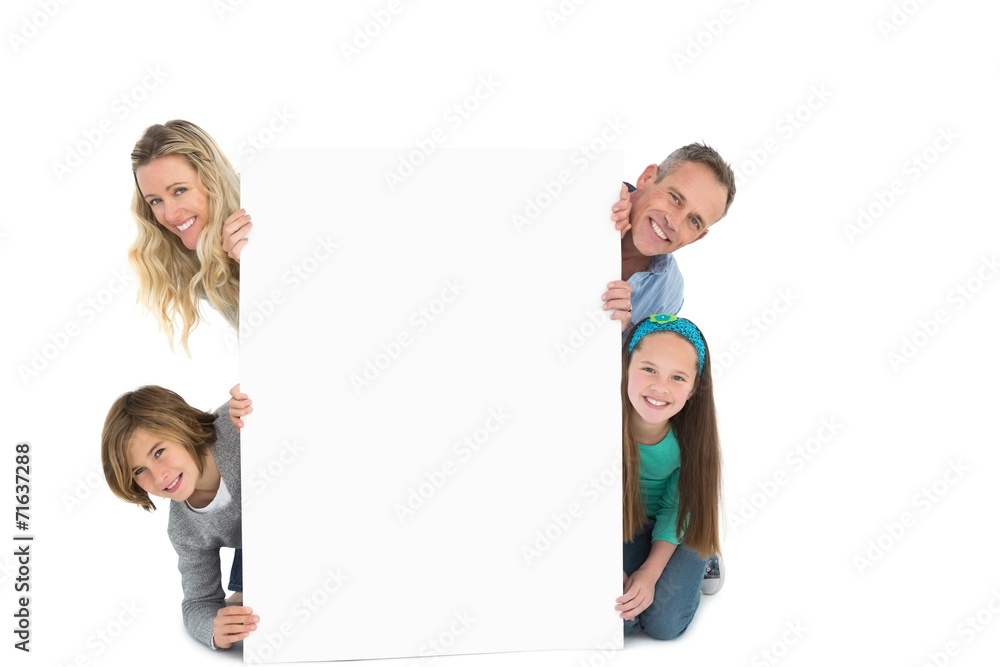 Cute family smiling at camera holding poster Cute family smiling at camera holding poster