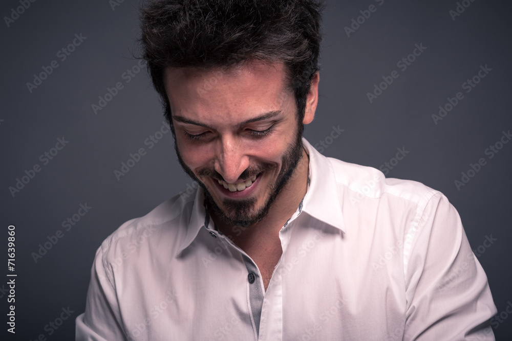 Smiling man close up portrait against dark background.
