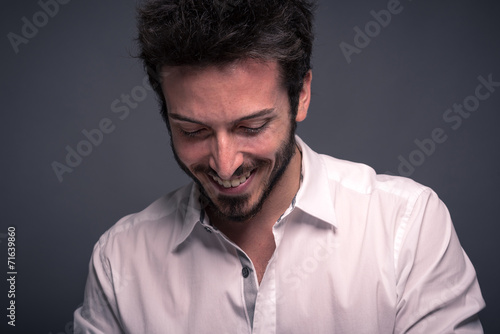 Smiling man close up portrait against dark background.
