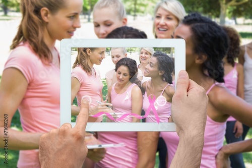 Composite image of hand holding tablet pc