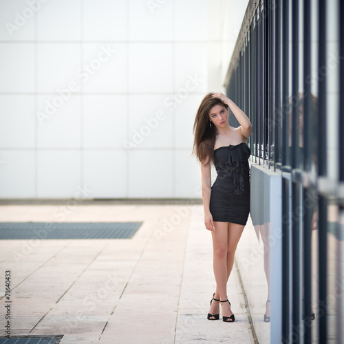 Young attractive brunette woman in front of modern building.